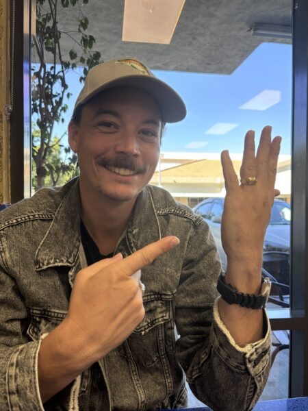 A client pointing at his recovered ring, back on his finger